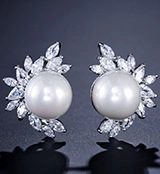 Macro shot of silver drop earrings featuring white round pearls and marquise-cut zircons