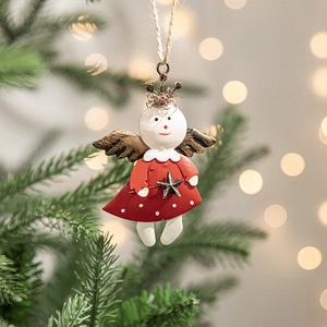Hand-painted metal angel ornament on Christmas tree branch with warm bokeh lights