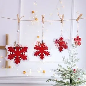 Close-up of red and white double-layer snowflake ornaments with twine and wood clips