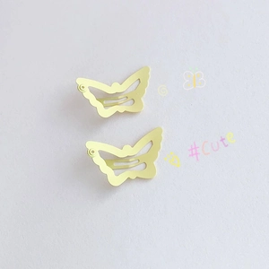 Close-up of yellow butterfly hair clips with cute matte finish and镂空 wings detail