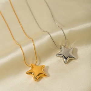 Close-up of gold and silver star necklaces on soft beige silk fabric with smooth finish