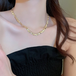 Detailed view of layered gold sequin choker necklace worn with black clothing