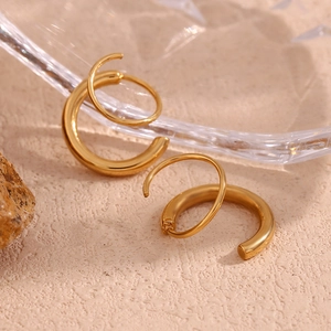 Détail macro de boucles d'oreilles créoles doubles spirales en acier plaqué or 18K
