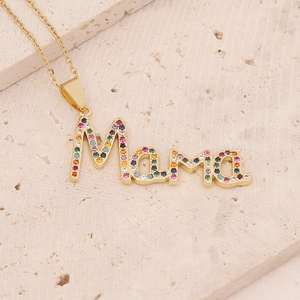 18K gold plated Mama necklace with colorful zircon stones on a textured stone surface