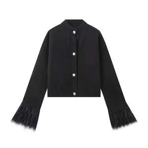 Detail eines schwarzen Strick-Cardigans mit Silberknöpfen und Pelzbesatz an den Ärmelbündchen
