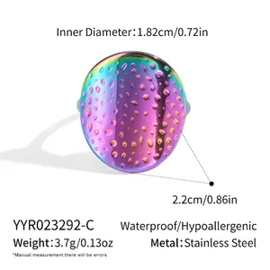 Macro view of iridescent rainbow stainless steel ring with textured water droplet pattern