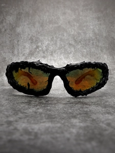 Macro shot of futuristic black liquid-textured frames with orange polarized lenses