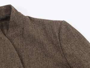Dettaglio macro della cucitura della spalla e del colletto del blazer marrone