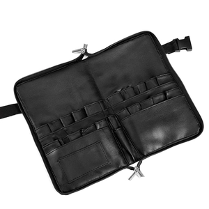 Macro view showing multiple slots and compartments of the black leather makeup brush bag