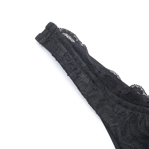 Gros plan sur la broderie de dentelle complexe et les motifs floraux de la robe noire