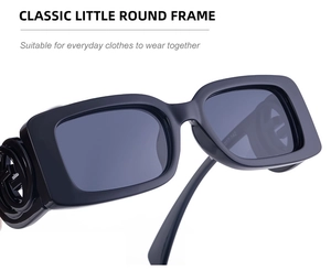 Detail of black rectangular sunglasses featuring a distinctive circular logo on the temple