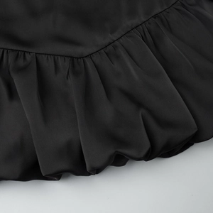 Detailed macro view of black bubble skirt with pleated fabric texture and satin sheen