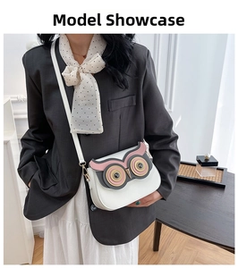 Close-up of white owl-shaped PU leather crossbody bag with cute layered eyes and gold beak
