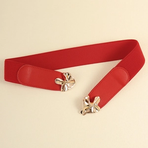 Detail of red elastic waist belt featuring golden flower-shaped buckle and PU leather