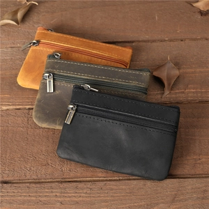 Porte-monnaie rétro en cuir véritable marron, vert et noir sur une surface en bois