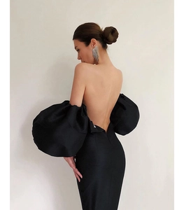 Detail of elegant black off-shoulder party dress featuring dramatic puff sleeves and open back