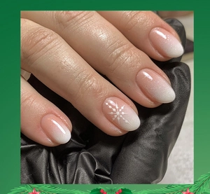 Detail of pink and white gradient almond press-on nails with white snowflake art