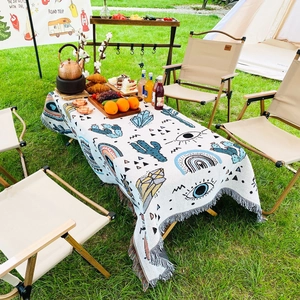 Detail of bohemian woven cotton blanket featuring cactus patterns and fringe edges