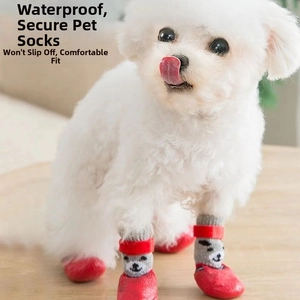 Waterproof dog boots with non-slip red soles and secure straps on a white Bichon Frise