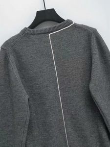 Detail of dark grey knit sweater featuring a contrasting white vertical back stripe