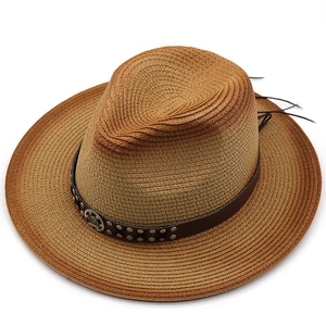 Detail of western straw fedora with leather band, metal studs and engraved badge