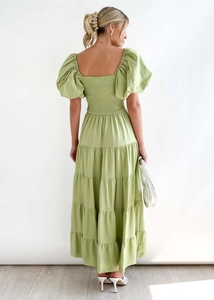 Detail view of the back smocked waist and layered tiered skirt of the green puff sleeve dress