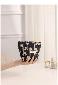 Detail of navy blue giraffe pattern fabric cosmetic bag with flower zipper puller