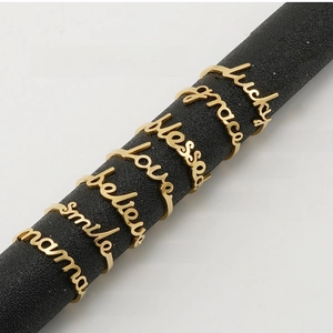 Set of 7 gold stainless steel rings featuring cursive words like Lucky and Mama