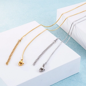 Elegant gold and silver snowflake snake chain necklaces set on geometric display