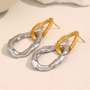 Macro detail of geometric two-tone hammered texture earrings in gold and silver finish