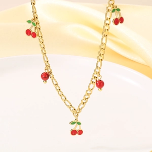Detail of 18K gold necklace featuring red cherry pendants and natural stone beads