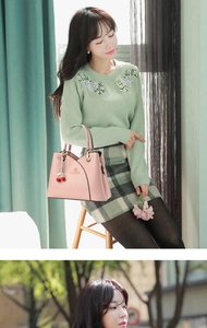 Pink faux leather tote with lychee texture and cherry charm held by a model