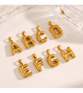 Detailed view of polished golden balloon-style alphabet charms from A to H for DIY jewelry