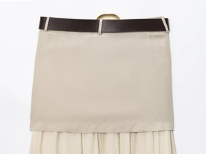 Détail d'une jupe midi en lin beige avec ceinture en similicuir marron et boucle dorée