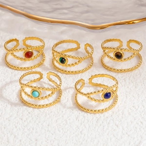 Detailed view of five 18k gold open rings with various colorful natural gemstones