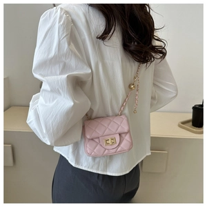 Detailed back view of a pink quilted mini bag with gold chain and ball charm accessory