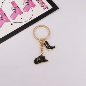 Detail showing vintage golden cowboy hat and boot keychain charms with black enamel finish