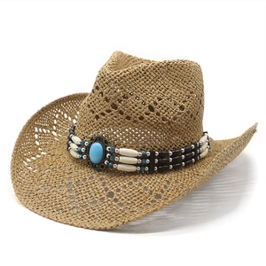 Retro hollow-out straw western cowboy hat with turquoise bead band on white background