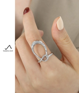 Macro shot of silver stainless steel horseshoe ring with cubic zirconia on model
