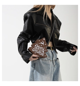 Detailed view of dark brown Christmas tree crossbody bag with silver chain strap on model
