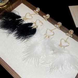 Elegant heart earrings with long feather tassels and crystal studs in black and white