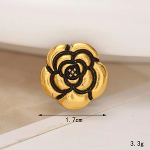 Detail of a 1.7cm golden metal camellia flower shoe charm with polished petal textures