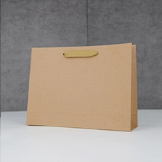 Close-up of minimalist kraft paper shopping bag with sturdy handles on a gray background