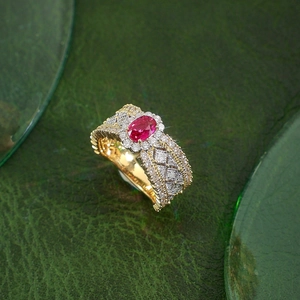 Macro detail of luxury gold ring with oval ruby main stone and intricate diamond pavé setting