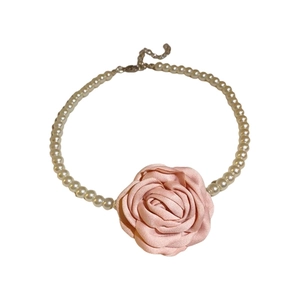 Élégant collier de perles avec pendentif rose rose et fermoir en métal sur fond blanc