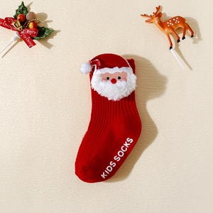 Détail de chaussette de Noël rouge pour bébé avec renne en peluche et semelle antidérapante