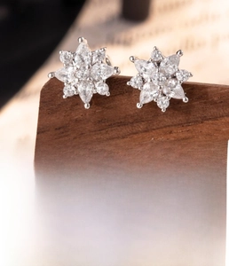 Details von silbernen Schneeflocken-Ohrsteckern aus Titanstahl mit Zirkonia-Kristallen