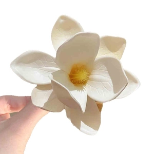 Frangipani fabric flower hair clip with matte cream petals and bright yellow center