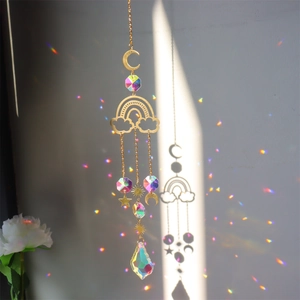Golden suncatcher with crystal stars and moon creating colorful rainbows on the wall