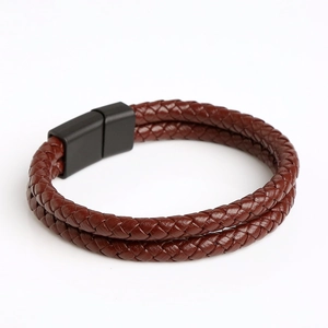 Detail of a brown double-layer braided leather bracelet with a black magnetic metal clasp